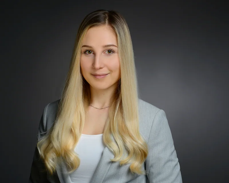 Frau mit langen hellen Haaren in einem hellblauen Blazer