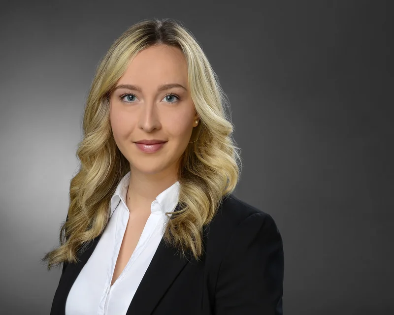 Bewerbungsportrait einer Frau im schwarzen Blazer mit weißer Bluse
