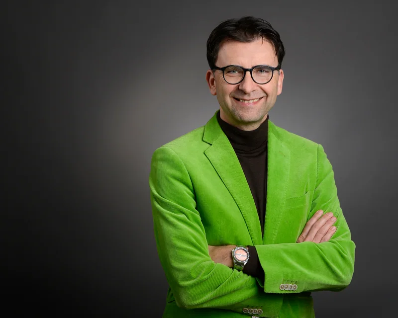 Lächelnder Mann mit Brille in grünem Sakko