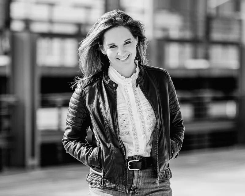 Anne Simon in Lederjacke vor einer Gebäudefassade