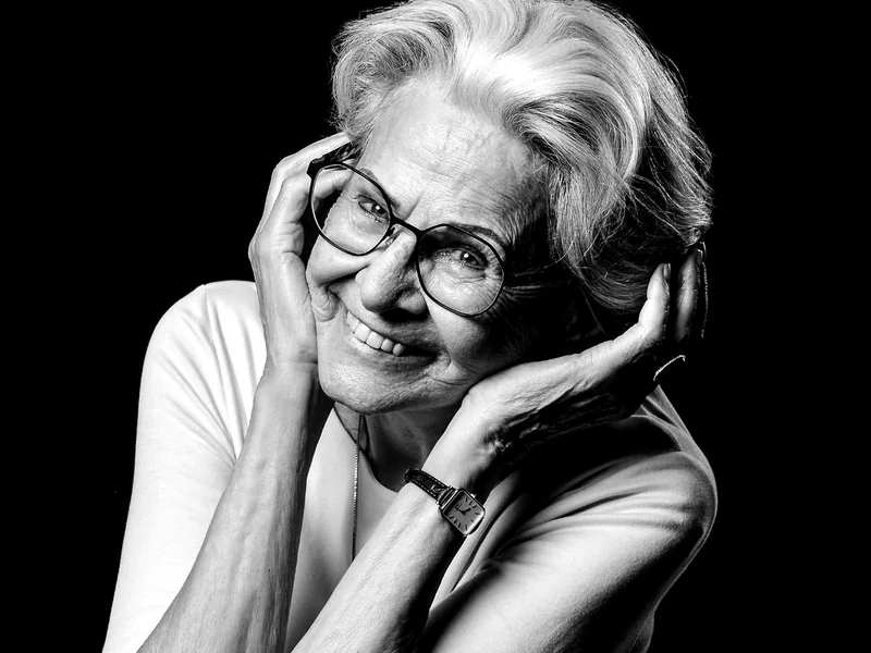 Eine Frau mit Brille legt ihre Hände an das Gesicht