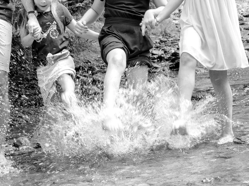 Mehrere Personen laufen gemeinsam durch flaches Wasser
