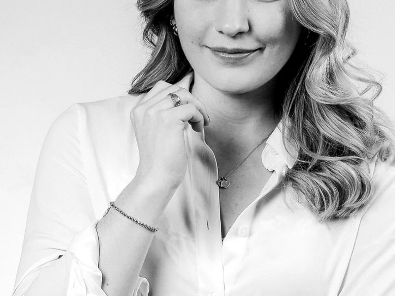 Schwarz-Weiß-Portrait einer lächelnden Frau in heller Bluse