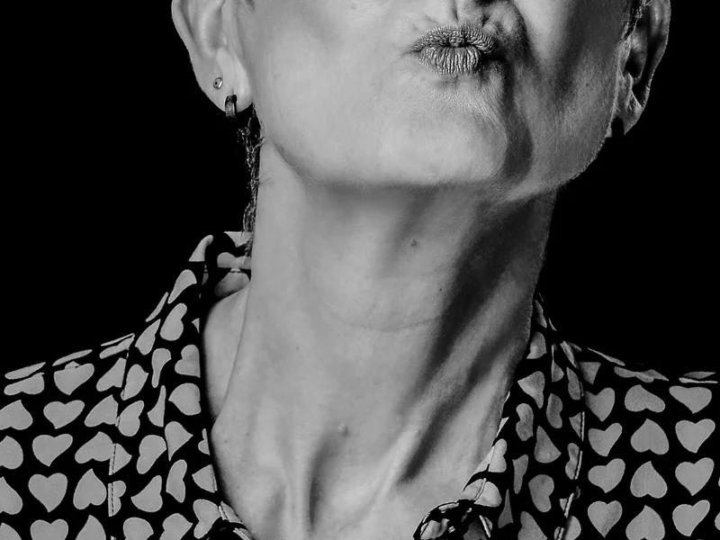 Detail eines Gesichts und einer gemusterten Bluse