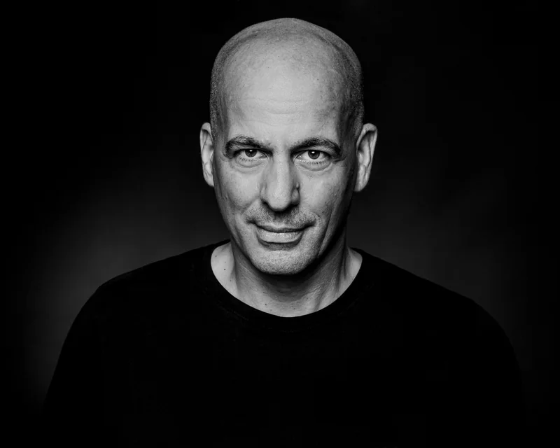 Schwarz-Weiß-Portrait eines Mannes im schwarzen Oberteil