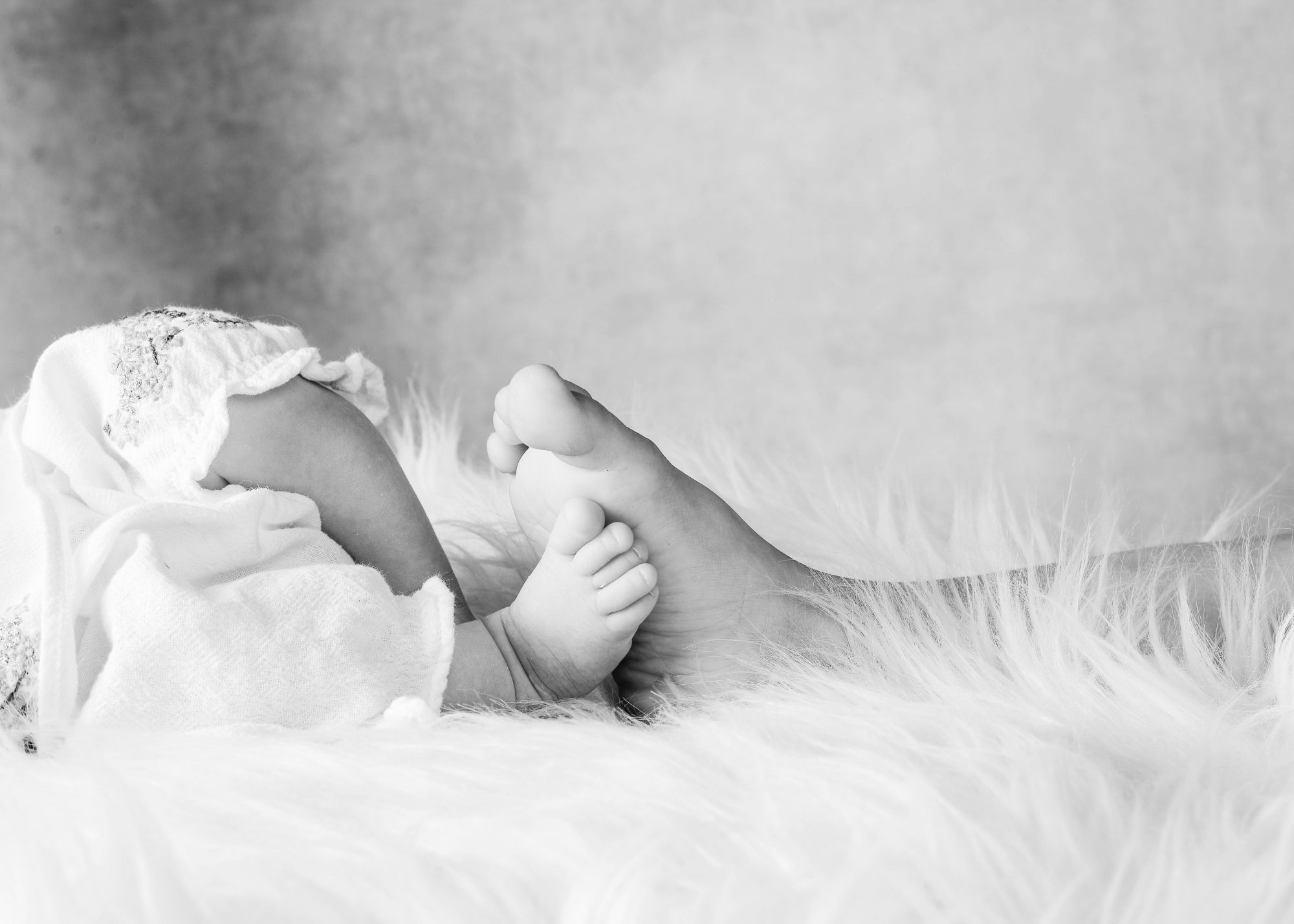 Ein Schwarz-Weiß-Foto der Füße eines Babys.